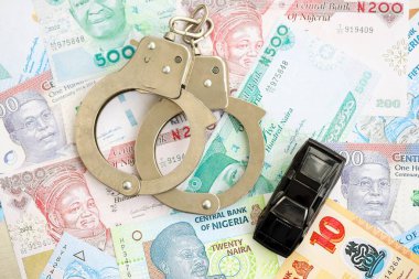 Nijerya naira para birimi faturaları ve kelepçeli oyuncak araba. Araba kazası kavramı.