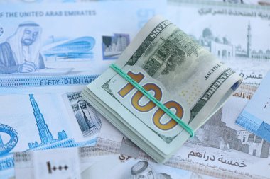 Birleşik Arap Emirlikleri kara para birimi faturaları ve biz dolar banknotları yakın yakın. Ekonomi ve döviz kuru kavramı