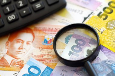Filipinler Peso para birimi faturaları ve yakınlaştırıcı bardaklı hesap makinesi. Vergilendirme ve para sayımı kavramı