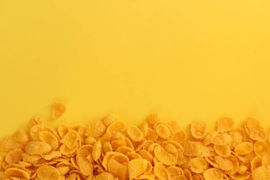 Kahvaltı gevreklerinin arka planında büyük miktarda sarı arka planda yakın plan, üst manzara