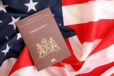 Hollanda pasaportu Amerika Birleşik Devletleri bayrağında sallanıyor. ABD Vize ve Göçmenlik Konsepti