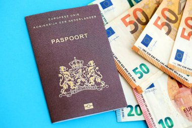 Hollanda pasaportu, mavi arka planda Avro para banknotlarıyla birlikte yakın planda bulunuyor. Avrupa 'da maaş ve emeklilik kavramı