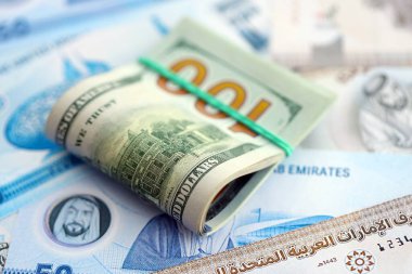 Birleşik Arap Emirlikleri kara para birimi faturaları ve biz dolar banknotları yakın yakın. Ekonomi ve döviz kuru kavramı