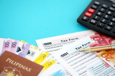 Filipinler pezosu para faturaları ve mavi üzerine yakın vergi formlu hesap makinesi. Vergi ve muhasebe kavramı