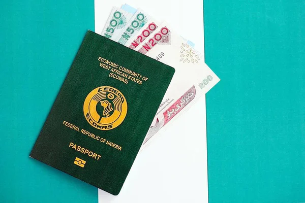 Nijerya nairası para ve pasaport banknotları bayrağın üzerinde. Seyahat ve tatil kavramı