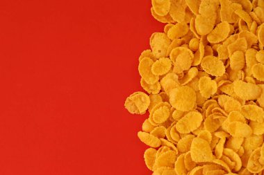 Kahvaltı gevreklerinin arka planında büyük miktarda kırmızı arka planda yakın plan, üst manzara.