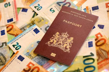 Hollanda pasaportu, yakın plandaki büyük miktardaki avroluk para banknotlarına dayanıyor. Avrupa 'da zengin yaşam ve seyahat kavramı