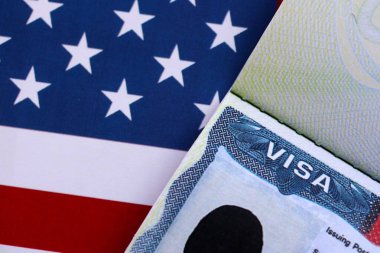 Birleşik Devletler bayrağı ve Birleşik Devletler vizesi. Göçmenlik ve Amerika Birleşik Devletleri 'ne seyahat kavramı. Amerikan bayrağının arka planındaki pasaportta vize var.