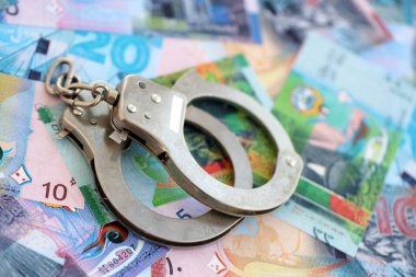 Kuwaiti dinar currency money bills and handcuffs close up. The concept of criminal