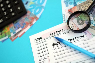 Kuveyt dinarı para faturaları ve mavi üzerine yakın vergi formlu hesap makinesi. Vergi ve muhasebe kavramı