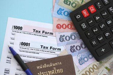 Tayland baht para faturaları ve mavi üzerine yakın vergi formlu hesap makinesi. Vergi ve muhasebe kavramı
