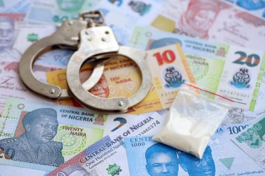 Nijerya naira para birimi faturaları ve kelepçeli kokain paketi. Uyuşturucu suçları kavramı