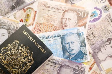 KYIV, UKRAINE - SEPTEMBER 17, 2025 Big amount of British pound money bills and passport close up
