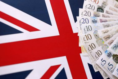 KYIV, UKRAINE - SEPTEMBER 17, 2025 Big amount of British pound money bills on Union Jack flag close up