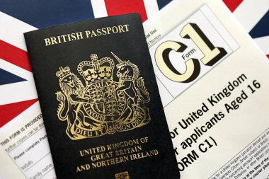 KYIV, UKRAINE - SEPTEMBER 17, 2025 C1 Form application for United Kingdom Passport for applicants aged 18 or over on flag close up