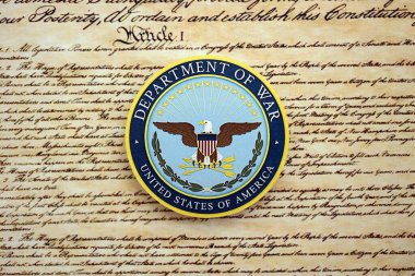 KYIV, UKRAINE - SEPTEMBER 17, 2025 US Department of War badge on first page of US Constitution replica close up