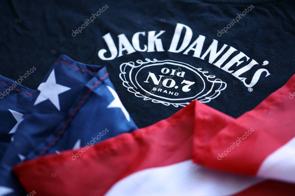 KYIV, UKRAINE - AUGUST 31, 2025 Jack Daniels Tennessee sour mash Whiskey logotype on fabric with US flag close up