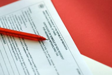 KYIV, UKRAINE - JANUARY 27, 2024 Indonesian tax form DGT certificate of domicile of non resident for indonesia withholding tax with pen lies on accountant table