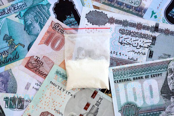 Egyptian pound currency money bills and cocaine pack close up. The concept of drug trafficking