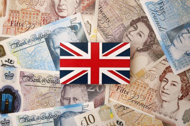 KYIV, UKRAINE - 17 Eylül 2025 Büyük miktarda İngiliz sterlini ve İngiliz bayrağı