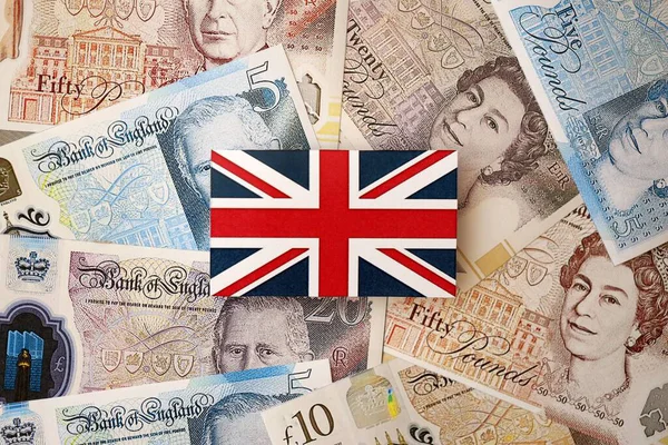 KYIV, UKRAINE - 17 Eylül 2025 Büyük miktarda İngiliz sterlini ve İngiliz bayrağı