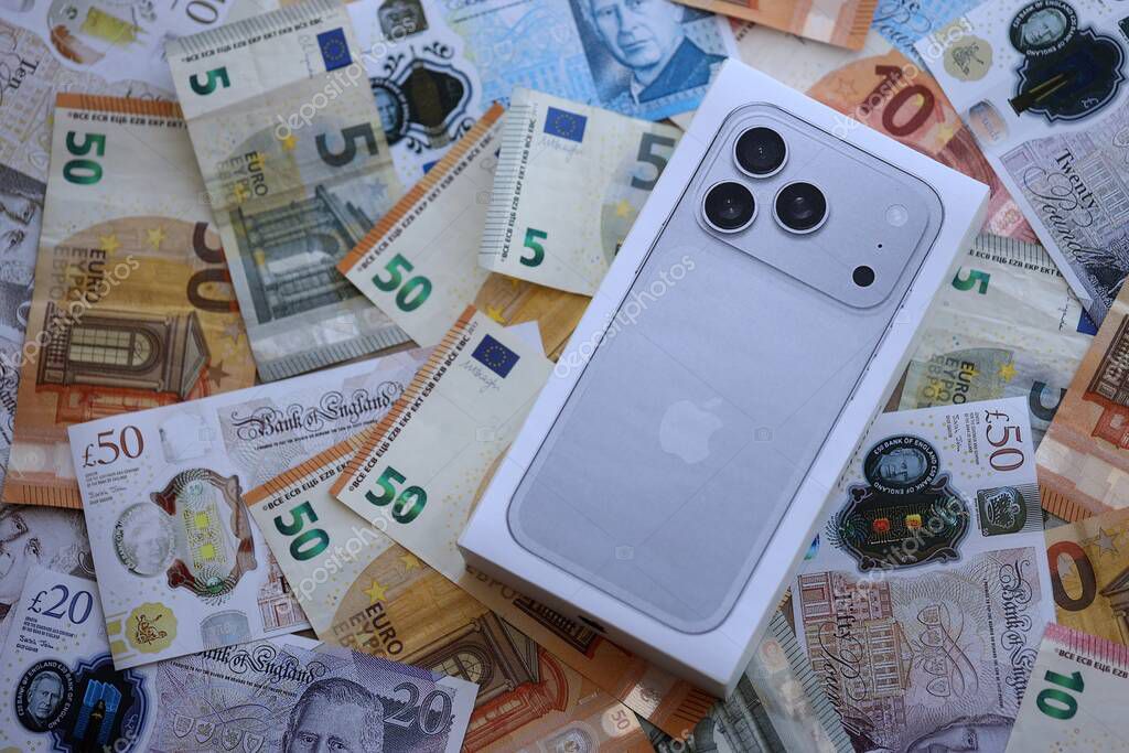 KYIV, UKRAINE - SEPTEMBER 21, 2025 Apple iPhone 17 Pro Max Silver box on big amount of GB pounds and euro bills close up