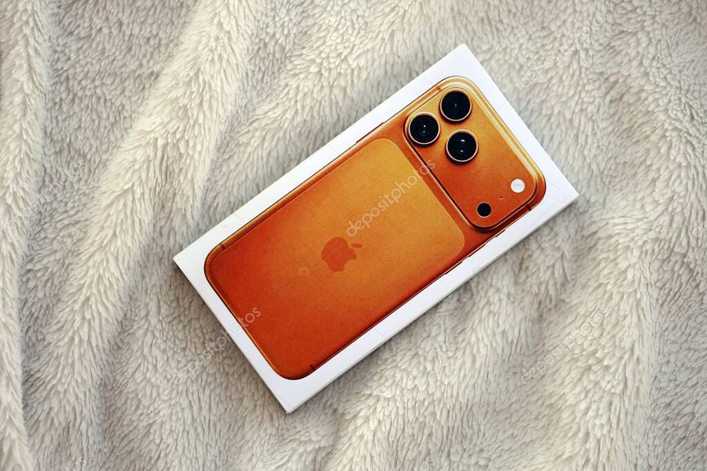 KYIV, UKRAINE - SEPTEMBER 21, 2025 Apple iPhone 17 Pro Max Cosmic Orange box on fluffy white plaid close up
