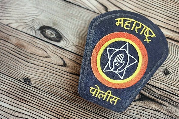 КИЕВ, УКРАИНА - 17 сентября 2025 года Индийский полицейский значок на поверхности коричневого деревянного стола крупным планом