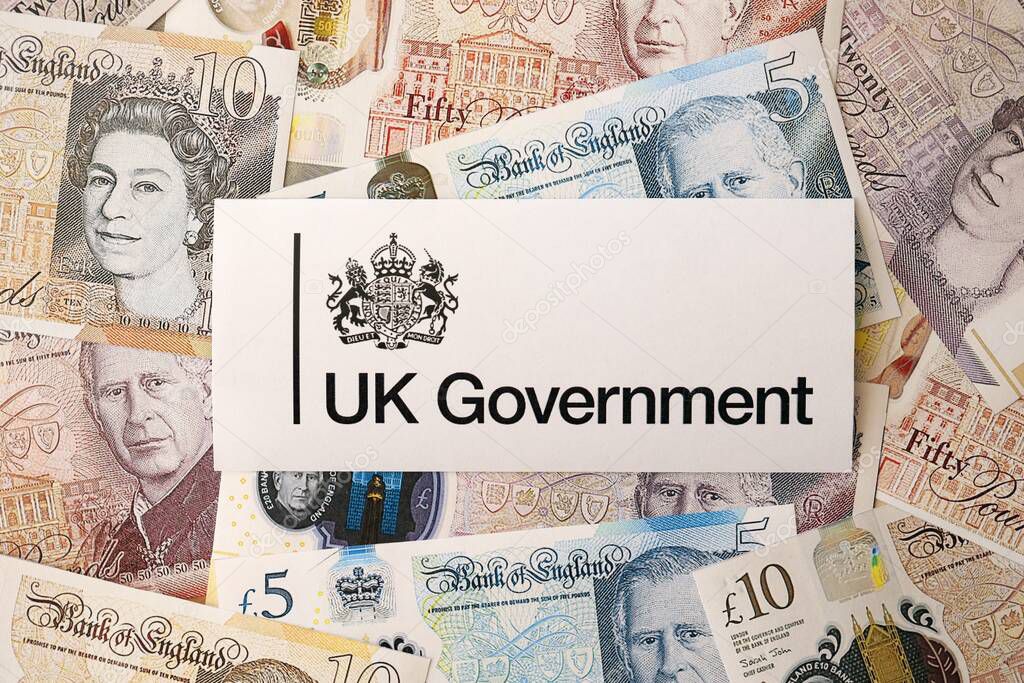 KYIV, UKRAINE - SEPTEMBER 17, 2025 Government GOV UK logotype sticker lies on British pounds money bills close up