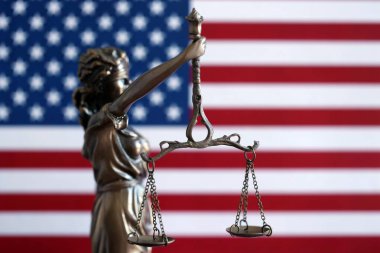 Hukuk ve adalet Amerika Birleşik Devletleri'ndeki bürolarından denetlenmekte, heykel Bayan Adalet ABD bayrağı arka planda, seçici odak ile