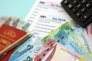 Bahreyn dinar para faturaları ve mavi üzerine yakın vergi formlu hesap makinesi. Vergi ve muhasebe kavramı