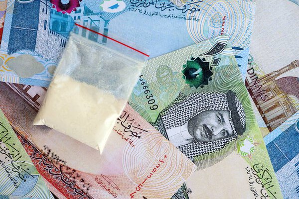 Bahraini dinar currency money bills and cocaine pack close up. The concept of drug trafficking