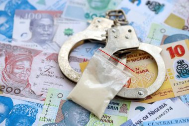 Nijerya naira para birimi faturaları ve kelepçeli kokain paketi. Uyuşturucu suçları kavramı