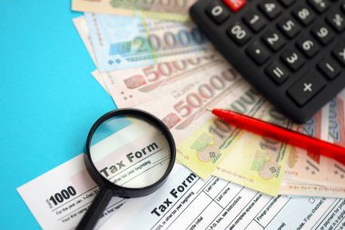 Vietnam çadırı para faturaları ve mavi üzerine yakın vergi formlu hesap makinesi. Vergi ve muhasebe kavramı