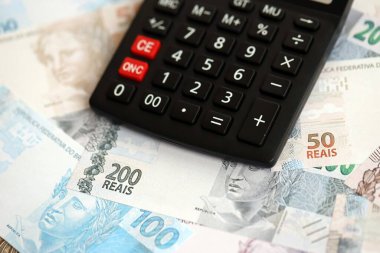 Brezilya banknotları ve hesap makinesi. Mevcut Brezilya gerçek para ve hesap makinesi büyük miktarda masada yatıyor. Brezilya 'da vergilendirme ve para konsepti