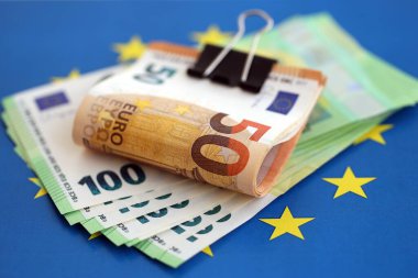 Avrupa sendikasının mavi bayrağına bir deste avroluk banknot yakın. Avrupa 'da iş ve ekonomi kavramı