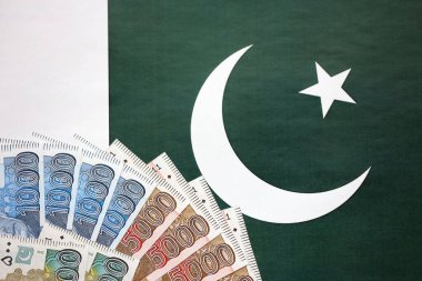 Pakistan 'ın bayrak geçmişi üzerine Pakistan banknotları. Pakistan 'ın mevcut para faturaları büyük miktarlarda pankartta yatıyor. Pakistan 'da ekonomi ve ticaret kavramı