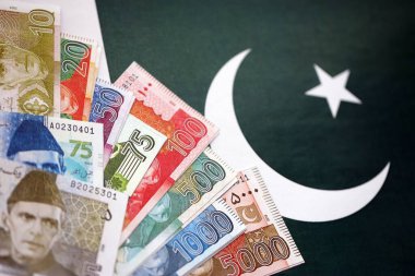 Pakistan 'ın bayrak geçmişi üzerine Pakistan banknotları. Pakistan 'ın mevcut para faturaları büyük miktarlarda pankartta yatıyor. Pakistan 'da ekonomi ve ticaret kavramı