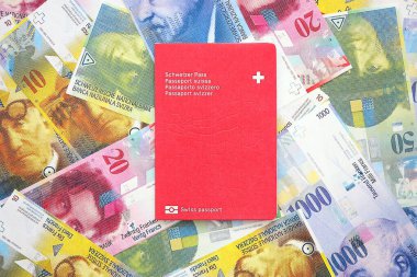 İsviçre frangı banknotları ve pasaportu. Mevcut banknotlar ve biyometrik geçiş kartları büyük miktarda masada yatıyor. İsviçre 'de seyahat ve tatil kavramı