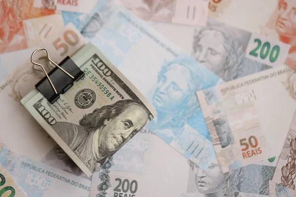 Bir sürü Amerikan doları büyük miktarda Brezilya banknotunun üzerinde yatar. Amerika 'nın parası Brezilya' nın para akışına bağlı. Brezilya 'da ekonomi ve döviz kuru kavramı