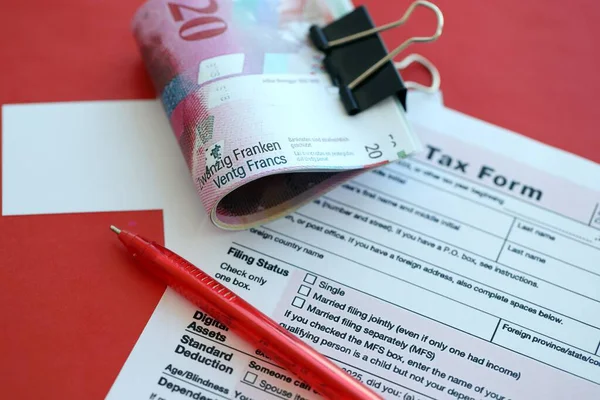 İsviçre frangı banknotları ve dolma kalemli vergi formu. Mevcut para faturaları vergi iade formunda yatıyor. İsviçre 'de vergilendirme kavramı