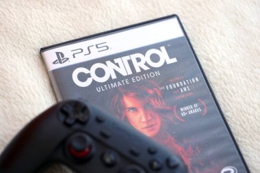 KYIV, UKRAINE - EPTEMBER 8, 2025 Control video oyunu siyah oyun alanı ile beyaz yumuşak ekose üzerinde uzanır