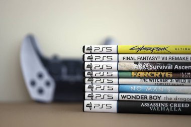 KYIV, UKRAINE - 17 Eylül 2025 PS5 video oyun disk kutuları ve modern dualsense kenar oyun sahası yakınlaşması