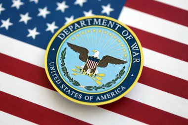 KYIV, UKRAINE - 17 Eylül 2025 ABD Savaş Bakanlığı rozeti Amerika Birleşik Devletleri bayrağına yakın