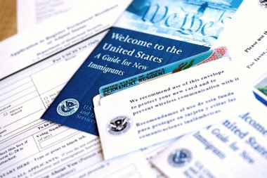 KYIV, UKRAINE - 31 AĞUSTOS 2025 Daimi ikamet yeşil kartı başvuru ve yeni göçmenler için rehber kapalı masada yatmaktadır