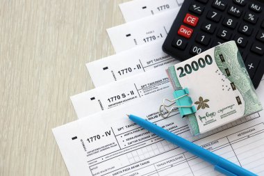 KYIV, UKRAINE - 27 Ocak 2024 Bireysel Gelir İade formları ve Endonezya rupia faturaları. Asıl adı Surat Pemberitahuan Pajak veya SPT Tahunan.