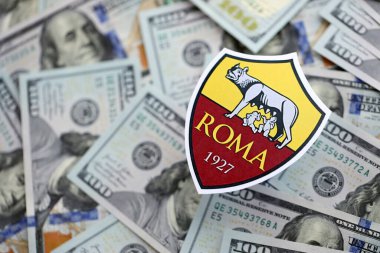 KYIV, UKRAINE - 23 Şubat 2025 Roma futbol kulübü rozeti yüzlük banknotların üzerinde yatıyor