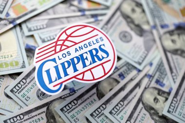 KYIV, UKRAINE - 23 Şubat 2025 Los Angeles Clippers basketbol takımı rozeti yüzlük banknotların üzerinde.