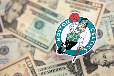 KYIV, UKRAINE - 23 Şubat 2025 Boston Celtics basketbol takımı rozeti Amerikan dolarlarının büyük bir miktarına yakın.