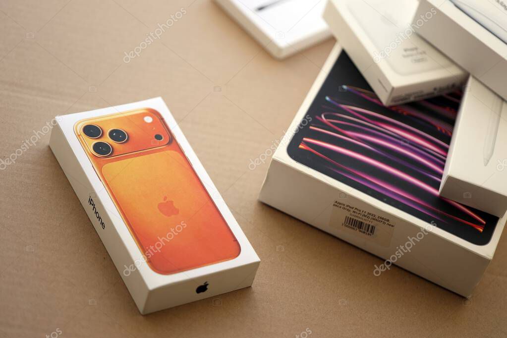 KYIV, UKRAINE - SEPTEMBER 21, 2025 Apple iPhone 17 Pro Max Cosmic Orange box and other apple products on cardboard surface close up